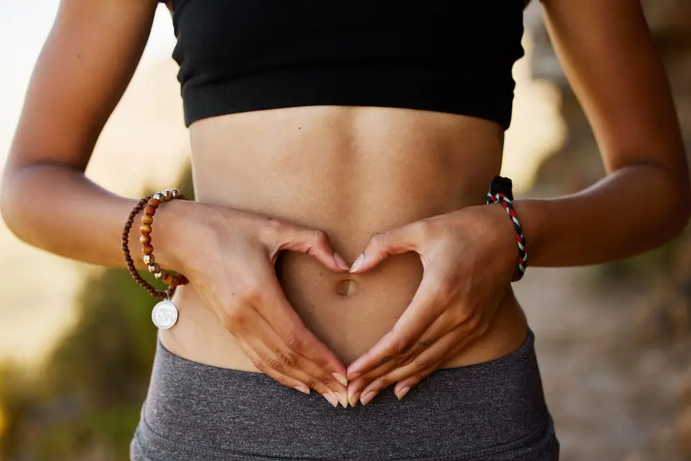 Women holding her hands to her stomach in a heart shape - promoting gut health